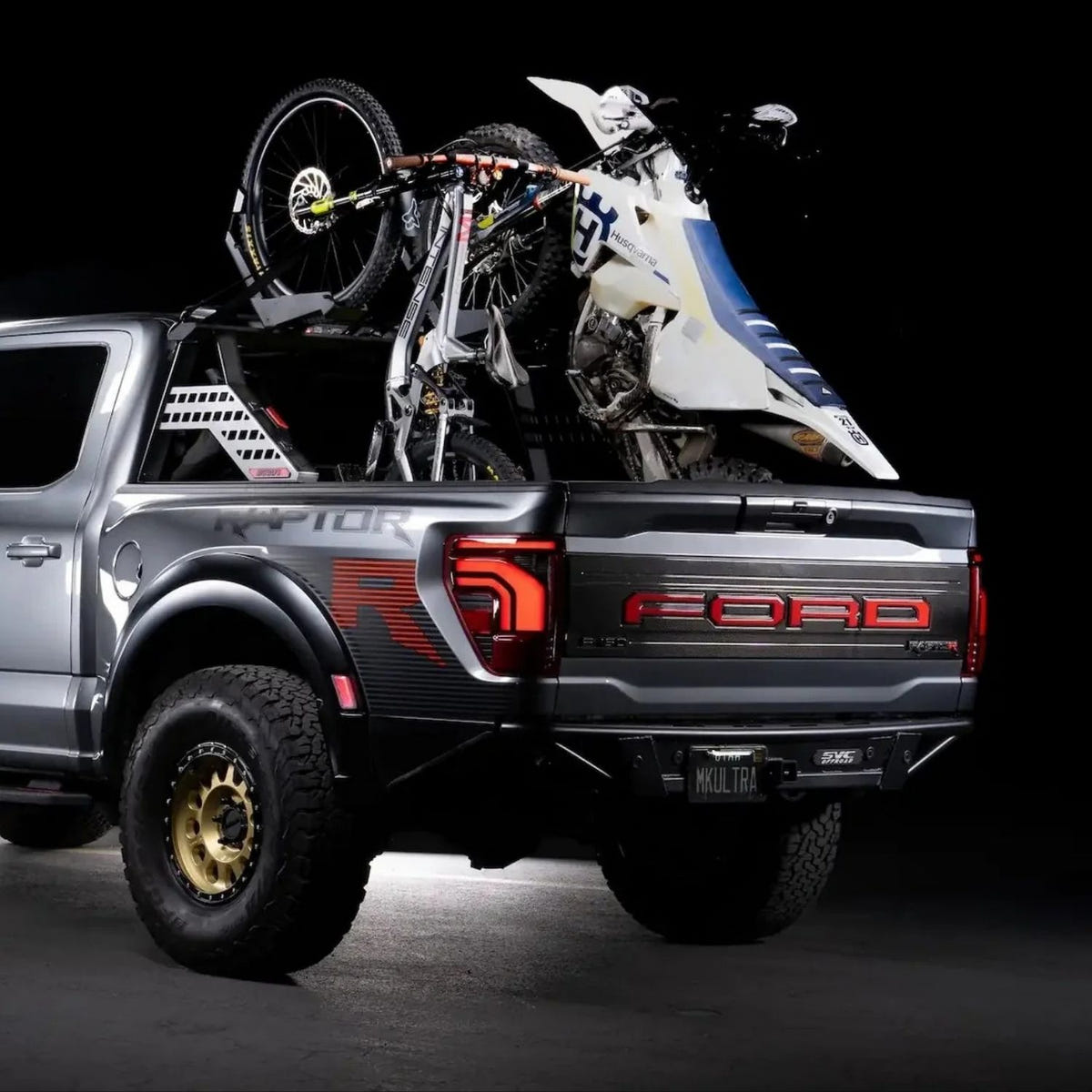 Truck bed rack carrying three mountain bikes and one dirt bike on a pickup truck