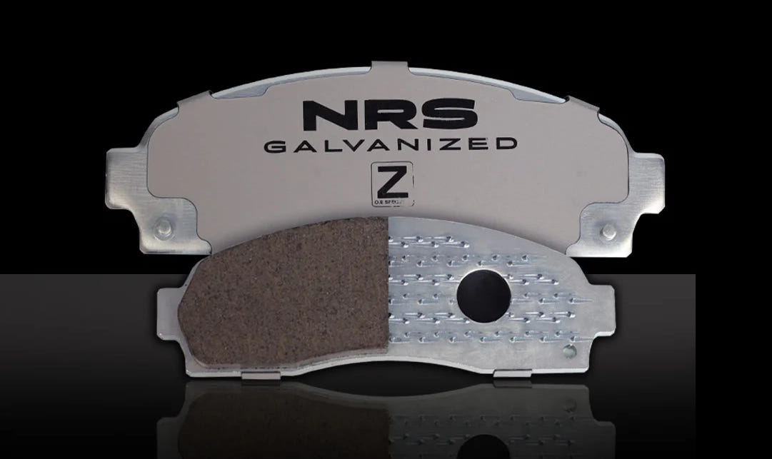 NRS Galvanized Z brake pad on a reflective black surface with a black background