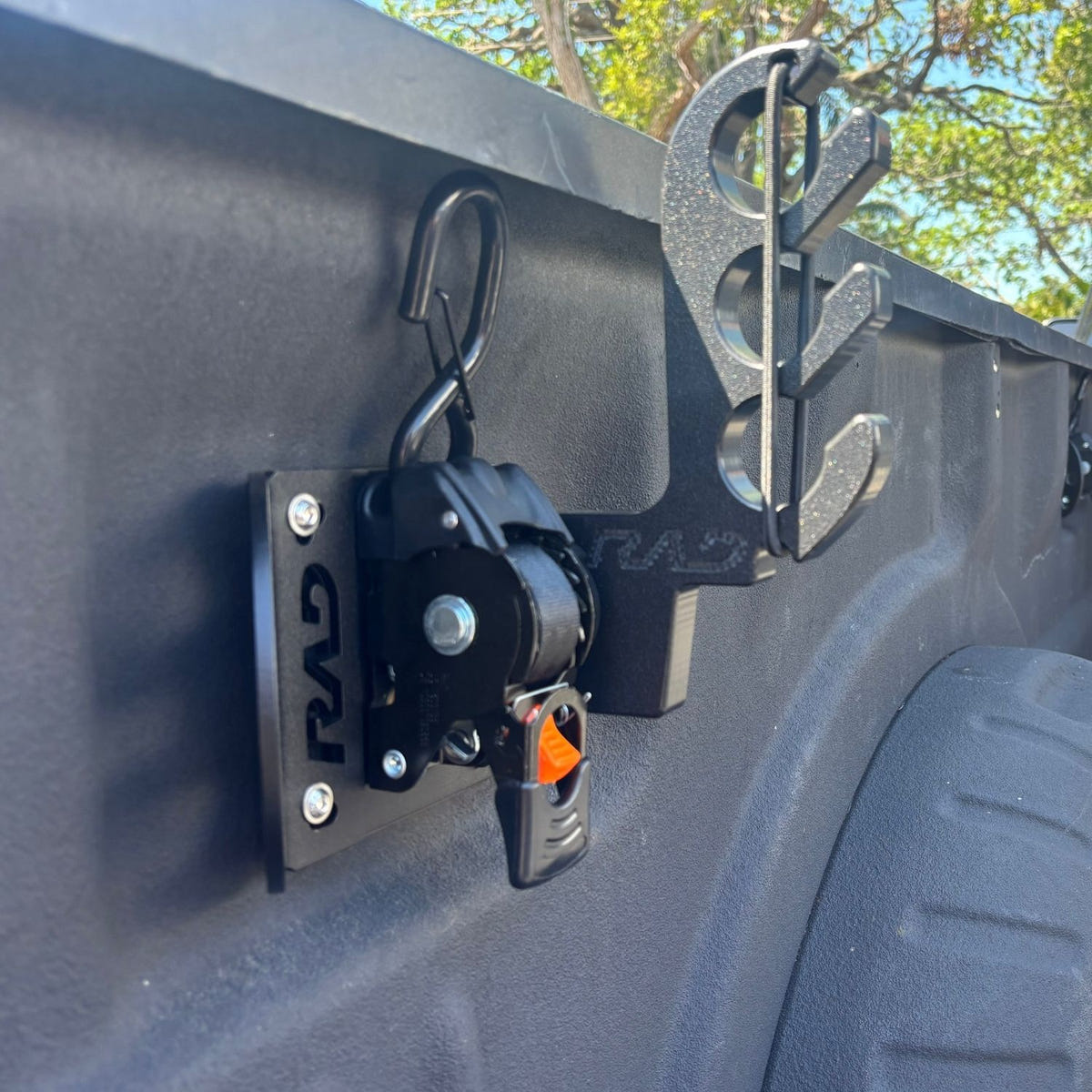 Low-profile RAD Fishing Rod Holder mounted in a truck bed with a bed cover protecting fishing rods during transport